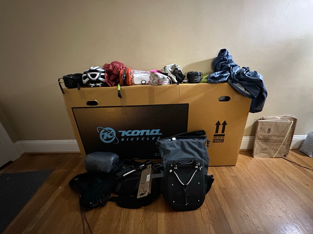 Boxed bicycle with various gear stacked on and in front of it.